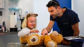 child with toy animal at vet